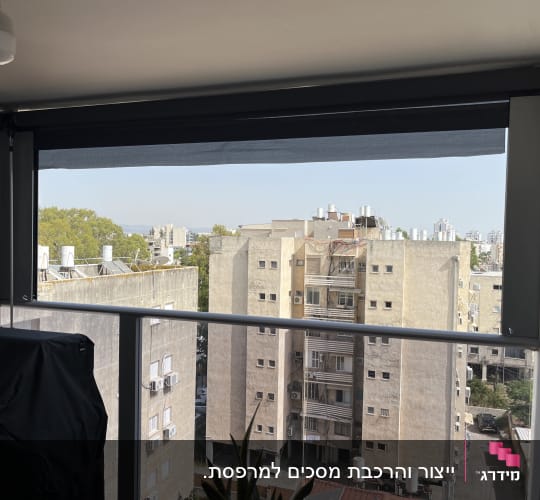 מרפסת עם סוכך גלילה כהה פתוח חלקית
